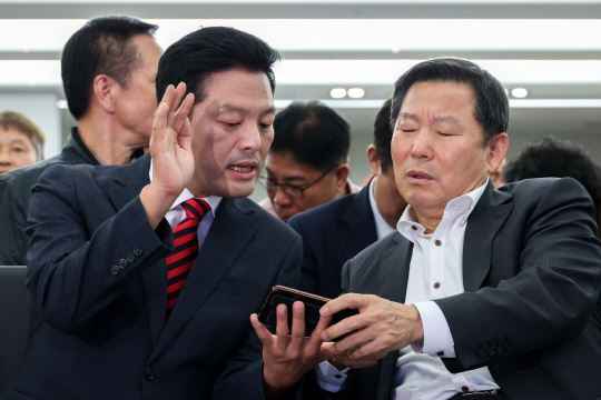 지난 10월11일 국민의힘 김태우(왼쪽) 당시 강서구청장 보궐선거 후보자가 보선 투표가 끝난 후 서울 강서구 선거사무실에서 이철규(오른쪽) 당 사무총장과 투표율을 확인하고 있다.<공동취재·연합뉴스>